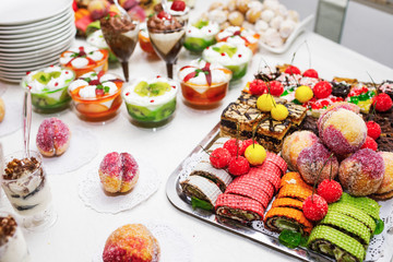 Modern desserts, cupcakes, sweets with fruits. Delicious candy bar. Catering Concept.