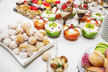Modern desserts, cupcakes, sweets with fruits. Delicious candy bar. Catering Concept.