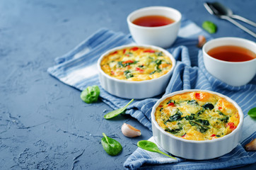Spinach Red Bell Pepper Baked Omelet with cups of tea and fresh spinach leaves