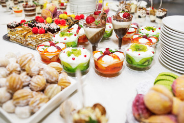 Modern desserts, cupcakes, sweets with fruits. Delicious candy bar. Catering Concept.