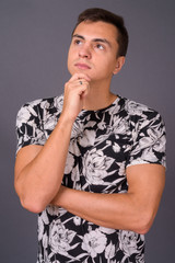 Studio shot of young handsome man against gray background