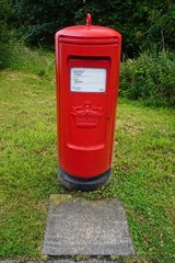 Fototapeta na wymiar A mailbox on a grassy lawn in Munlochy, Scotland.