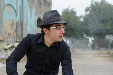 Fototapeta premium Hombre con sombrero, gafas y camisa negra fumando 02