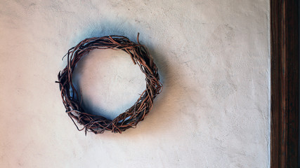 Handmade interior decorative wreath woven from the branches of the vine on the rustic wall - Powered by Adobe