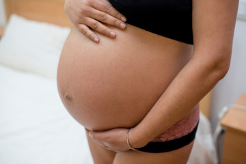 Fototapeta na wymiar Beautiful pregnant woman showing her belly