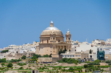 Fototapeta na wymiar Ancient hilltop fortified capital city of Malta, The Silent City, Mdina or L-Imdina, blue skies with huge walls, cathedral domes and towers