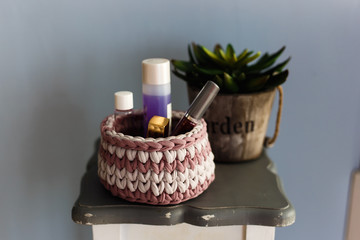 Knitted basket for small things and toys in the interior of the room