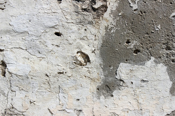 Deteriorating white and grey plastered wall texture background fragment