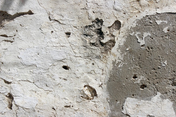 Deteriorating white and grey plastered wall texture background fragment