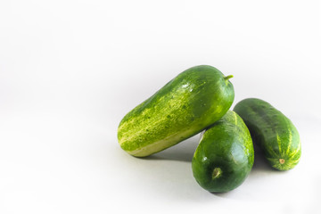 Three fresh cucumbers against a white background