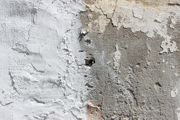 Deteriorating white and grey plastered wall texture background fragment