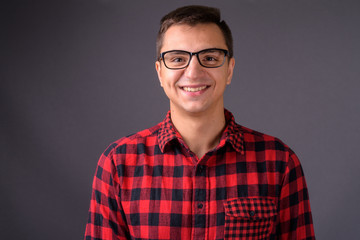 Studio shot of young handsome man against gray background