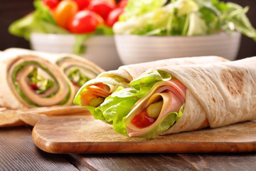 Tortilla wraps with with lettuce, ham and cheese sliced in half, healthy lunch snack