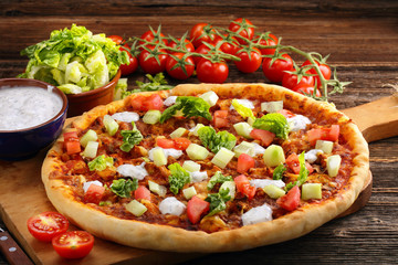 Greek style tzatziki sauce pizza on wooden background