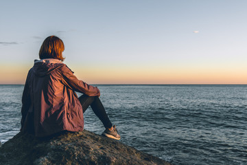 Woman on the beach, looking at the sea.