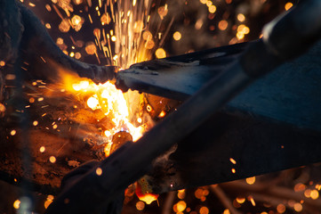 Horizontal abstract of flame and sparks from industrial cutting torch.