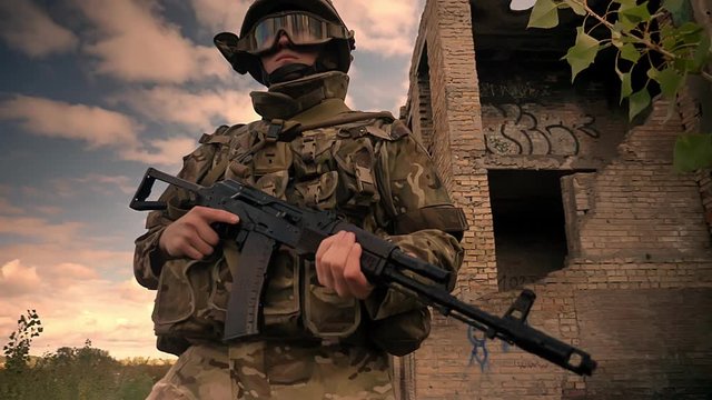 Resistant caucasian combatant in standing with gun confidently, wearing camouflage, abandoned buildings on background, military mood, cloudy