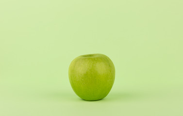 Green Apple isolated on Green Background. Clean & Fresh. Copy Space. Centered.
