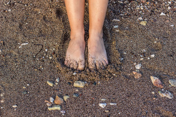 young female feet on sea sand background texture wallpaper pattern concept and empty copy space