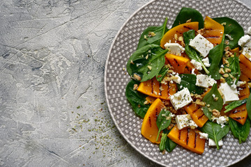Autumn pumpkin  salad with spinach, feta cheese and walnuts.Top view with copy space.