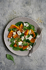 Autumn pumpkin  salad with spinach, feta cheese and walnuts.Top view with copy space.