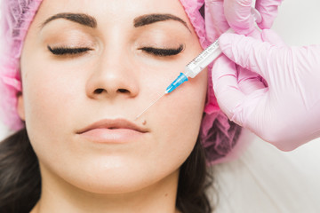Young woman getting cosmetic injection in beauty clinic