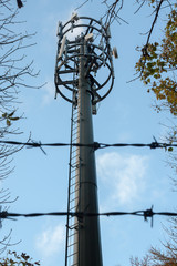Communications tower behind barbed wire - 231256529