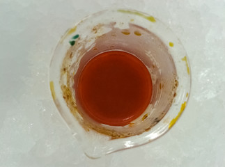 Synthesis of an orange chemical inside a glass beaker cooling in an ice bath