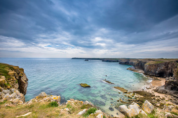Scenic bay on Pembrokeshire coast, Uk.Turquoise sea,rocky cliffs and dramatic sky.Beautiful landscape without people.