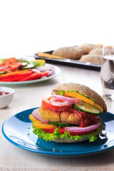 Healthy vegan burger with chickpea fritters, vegetables and whole-wheat bun with sesame and poppy seeds on white table for breakfast. Cooking, recipe