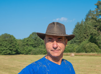 Portrait of a farmer in a hat in the field..