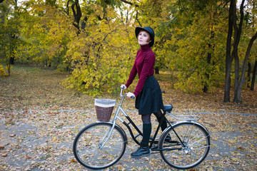 Obraz premium young woman riding on retro bicycle in the autumn park 