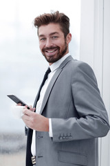 Stylish man in suit is reading information on phone