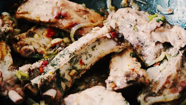 Baked pork ribs in a frying pan closeup. Selective focus.