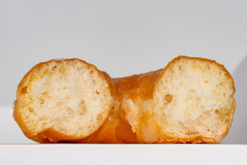 Macro close up of a glazed doughnut isolated on gray with copy space and a shallow depth of field