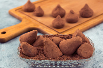 Chocolate truffles and cocoa powder in a glass plate.