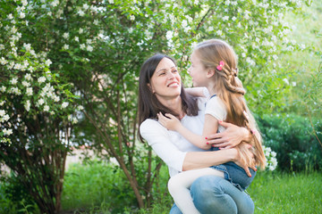 Fototapeta premium Mother holds her daughter outdoors