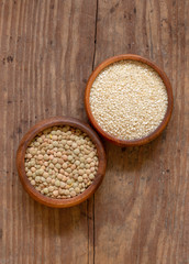 Sesame seeds and dried lentils in wooden bowls.