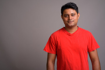 Obraz premium Portrait of young Indian man against gray background