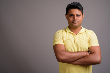 Portrait of young Indian man against gray background