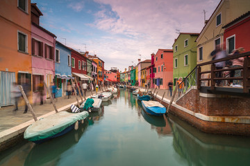 View on Rio Di San Mauro in Burano with passing people at sunset,long exposure photo.