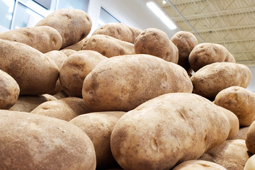 Closeup of a market stall with potatoes piled up