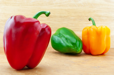 Colorful bell peppers on wooden table