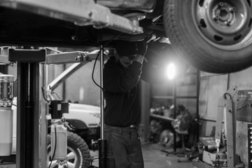 Young caucasian man repairing car with professional tools 