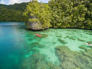 Kayaker and coral reef in Micronesia island scene