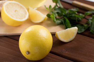 making lemon tea with mint on wooden cutting board