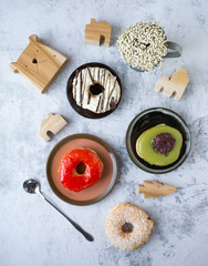 Variety of homemade donuts in wood tray on white background.