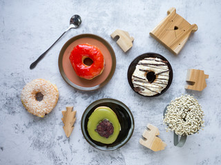 Variety of homemade donuts in wood tray on white background.
