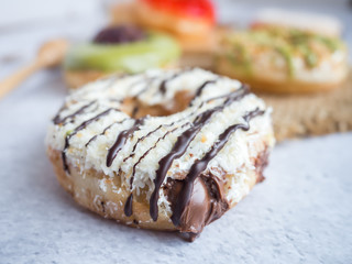 Variety of homemade donuts in wood tray on white background.