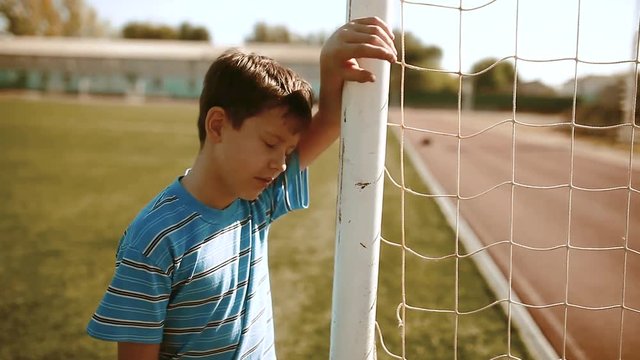 boy teenager soccer football player upset defeat insult sadness and anger. boy teenager grieved after the defeat, well, managed to win. soccer kids concept lifestyle